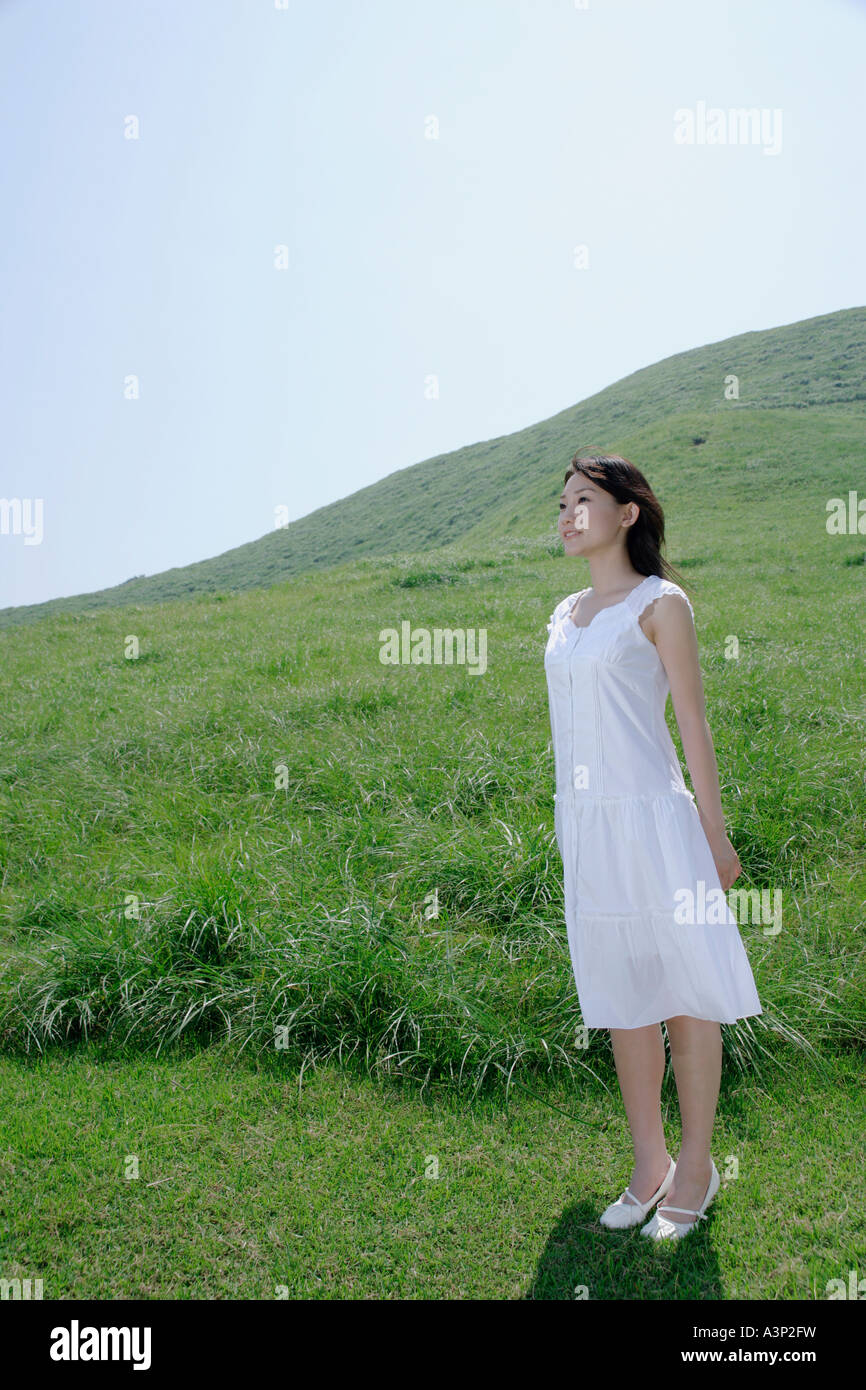 A young woman standing in field Stock Photo - Alamy