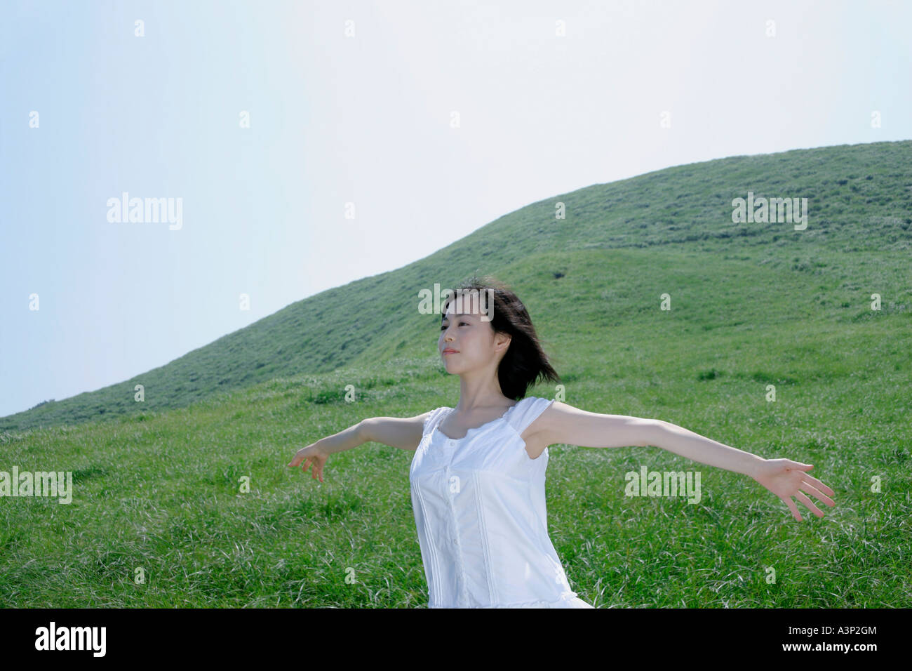 A young woman standing in field Stock Photo - Alamy