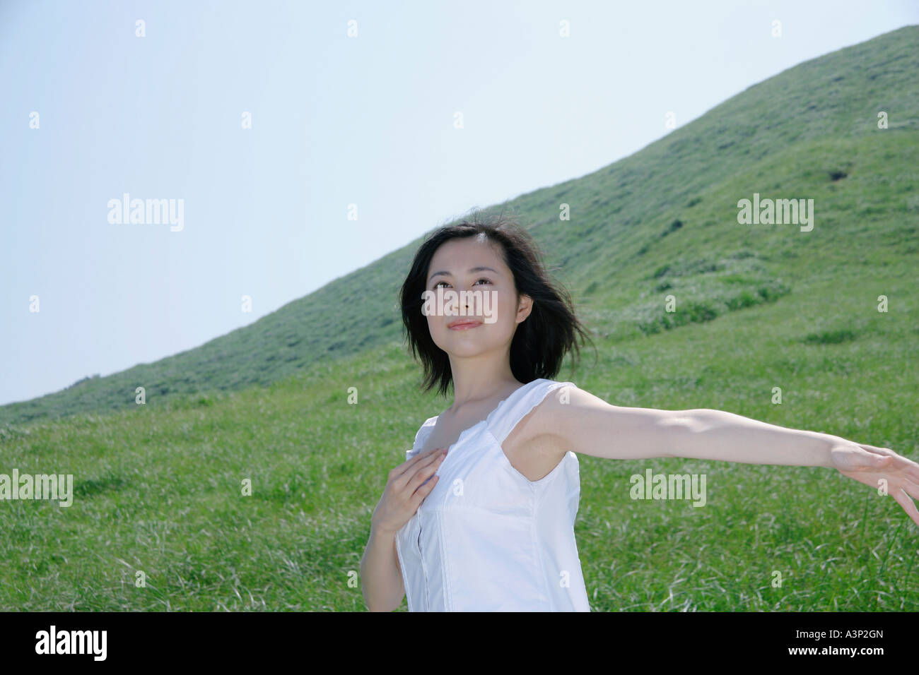 A young woman standing in field Stock Photo - Alamy