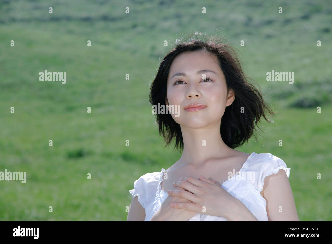 A young woman standing in field Stock Photo - Alamy