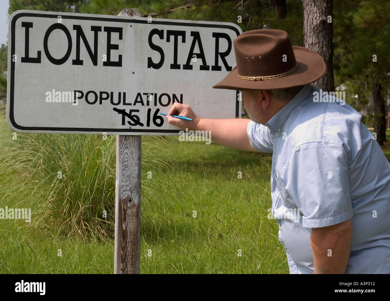 Man in cowboy hat changes population sign at Lone Star SC USA Stock ...