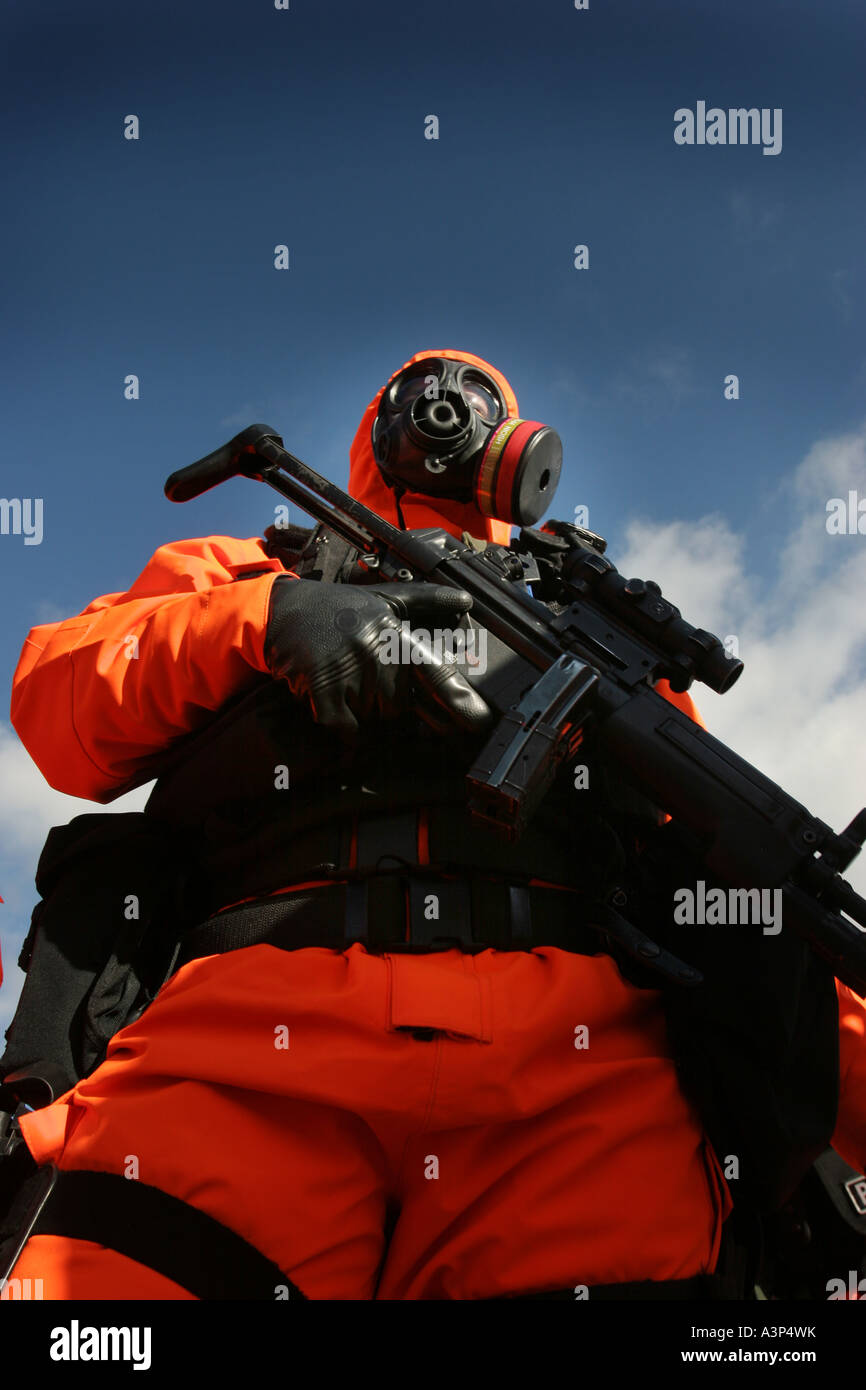 An armed police officer dressed in a chemical nuclear suit in the UK training for terror attacks Stock Photo