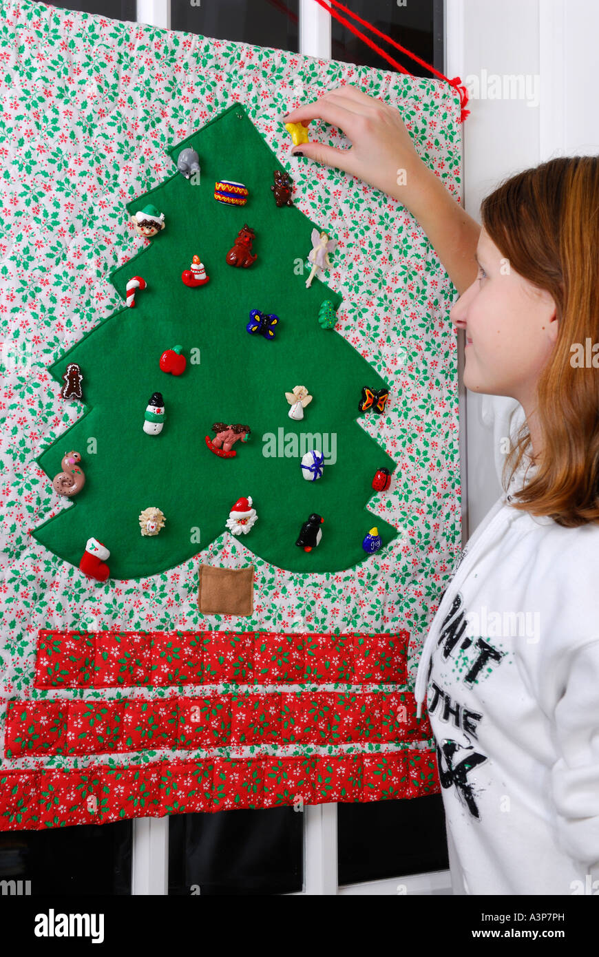 Young teenage girl placing the last ornament on the advent calendar christmas tree before Christmas Stock Photo