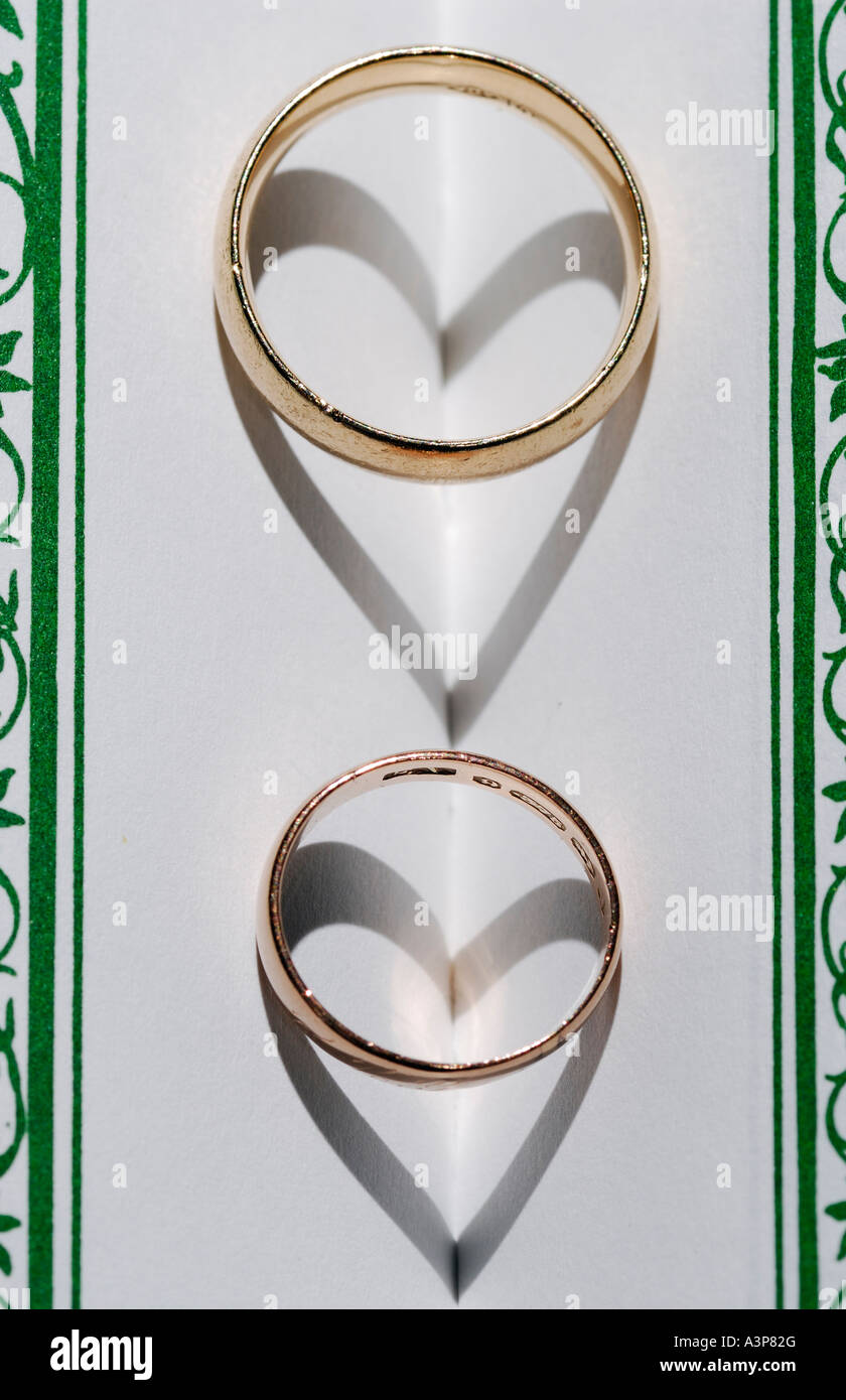 Pair of rings on a book spine forming heart shaped shadows of love Stock Photo