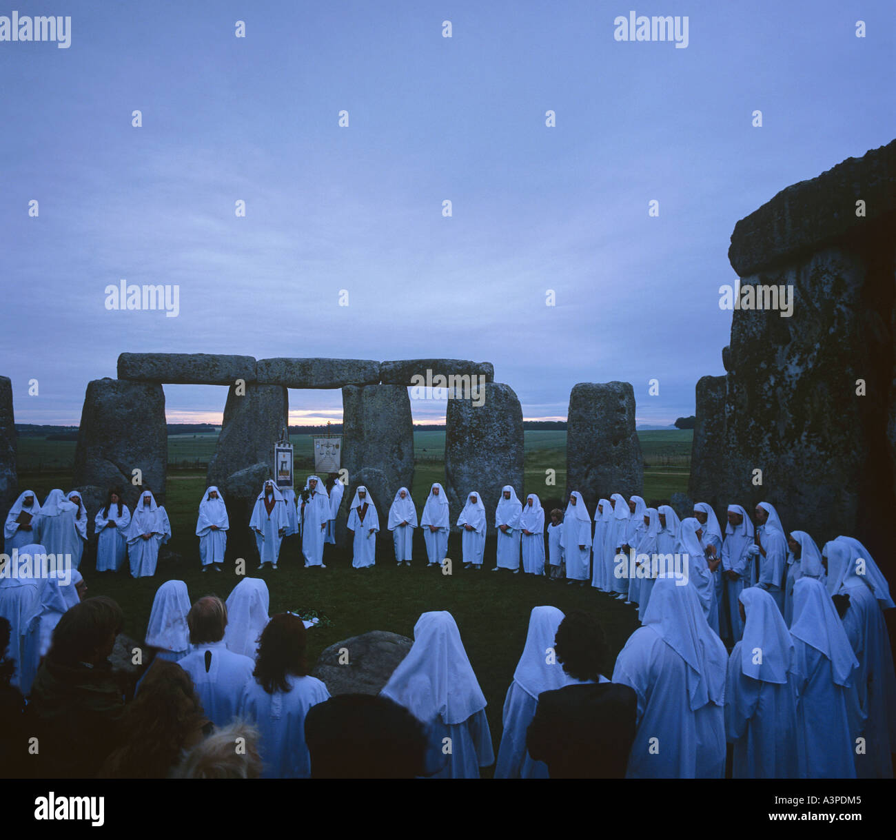 Druids celebrate the summer solstice at sunrise on June 21 within the ancient stone circle of Stonehenge Wiltshire Stock Photo