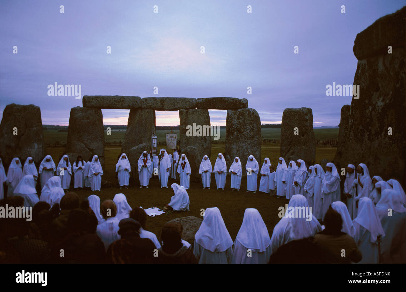 Druids celebrate the summer solstice at sunrise on June 21 within the ancient circle of Stonehenge Wiltshire England Stock Photo