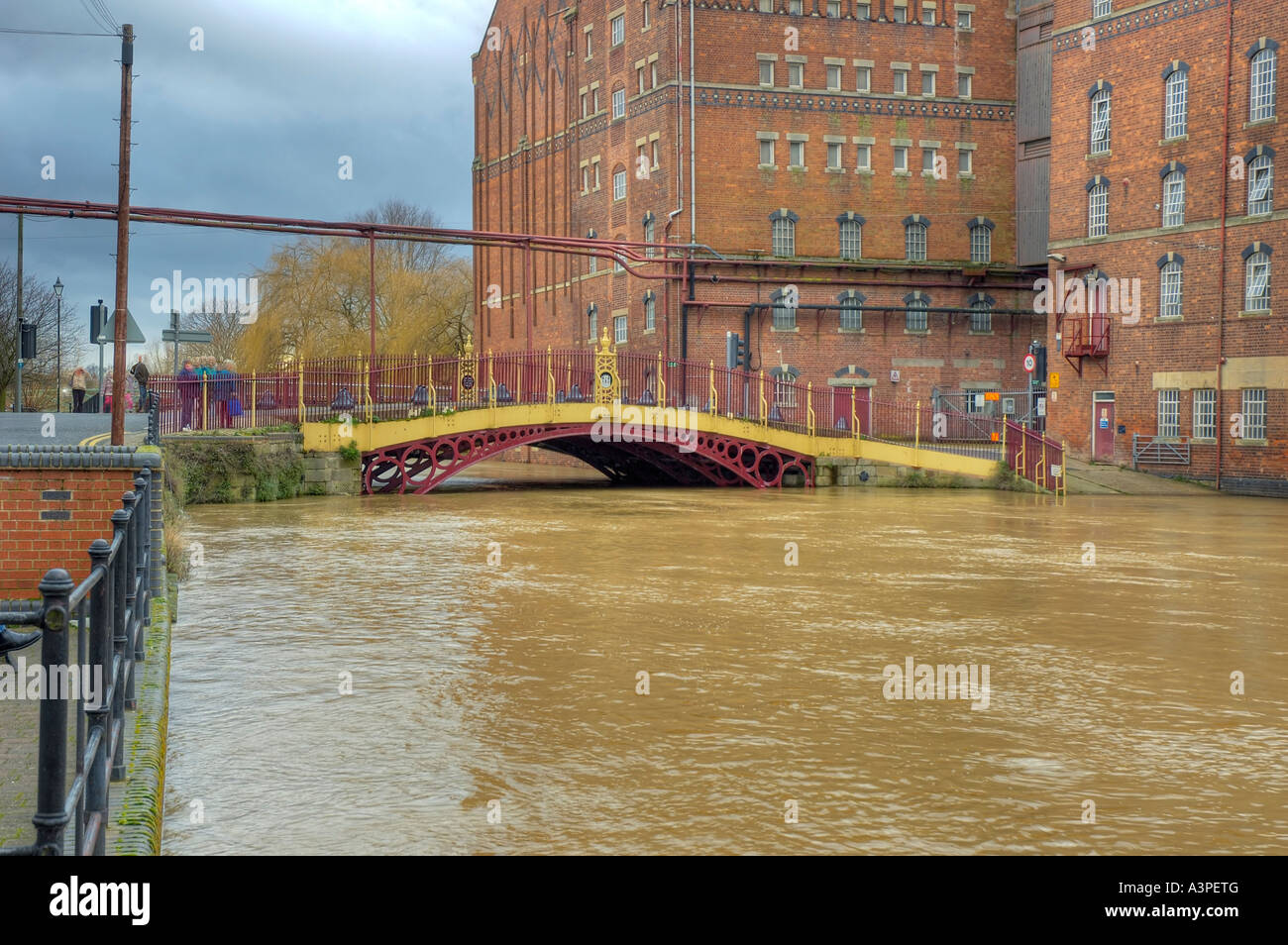 High water at Quay Street Bridge Decorated Iron bridge and Healings Flour Mill during Flood Stock Photo