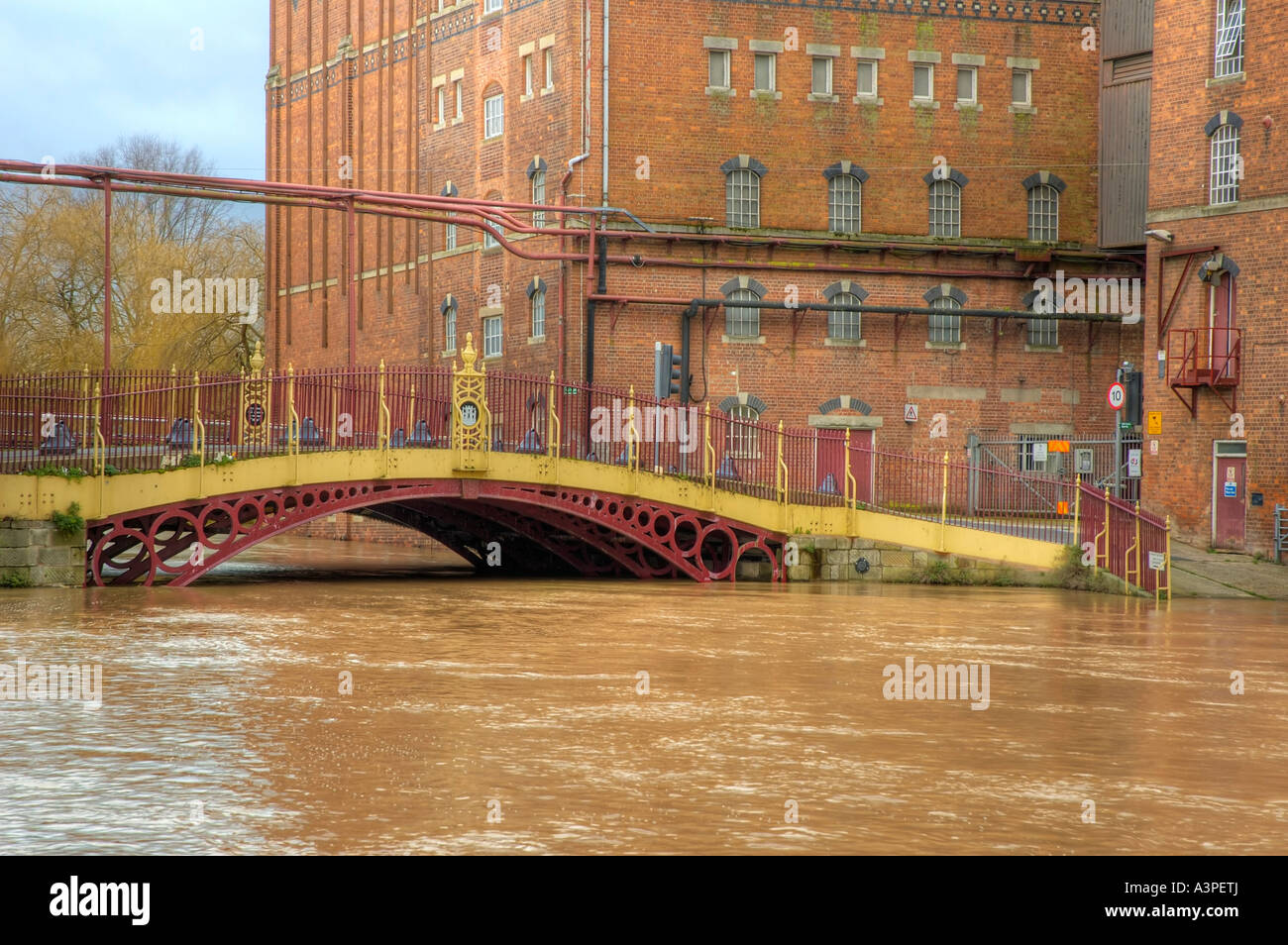 High water at Quay Street Bridge Decorated Iron bridge and Healings Flour Mill during Flood Stock Photo