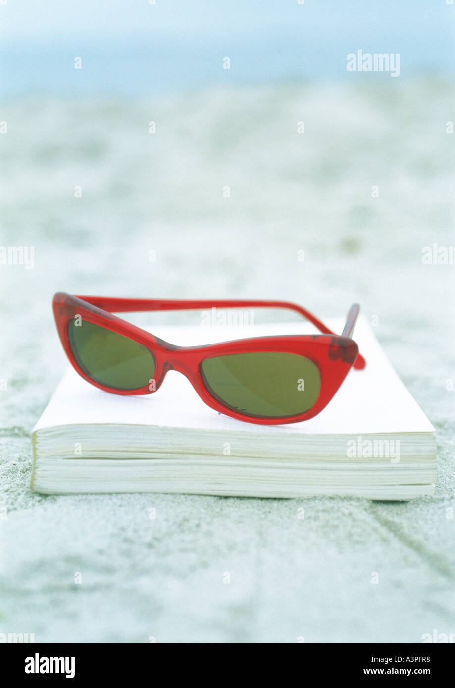 Sunglasses and book on sand Stock Photo Alamy