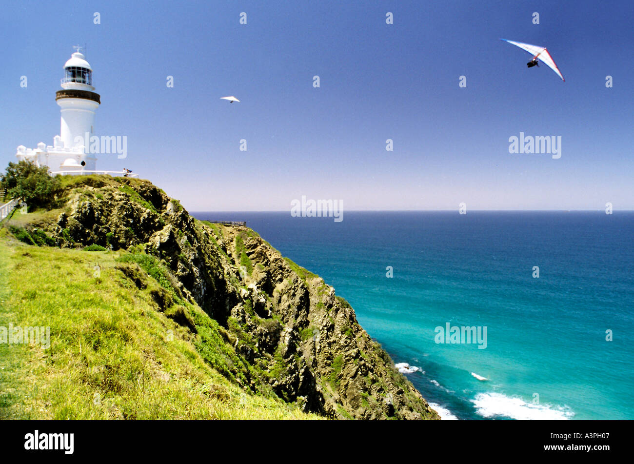 Cape Byron lighthouse with two hang gliders Byron Bay Australia Stock
