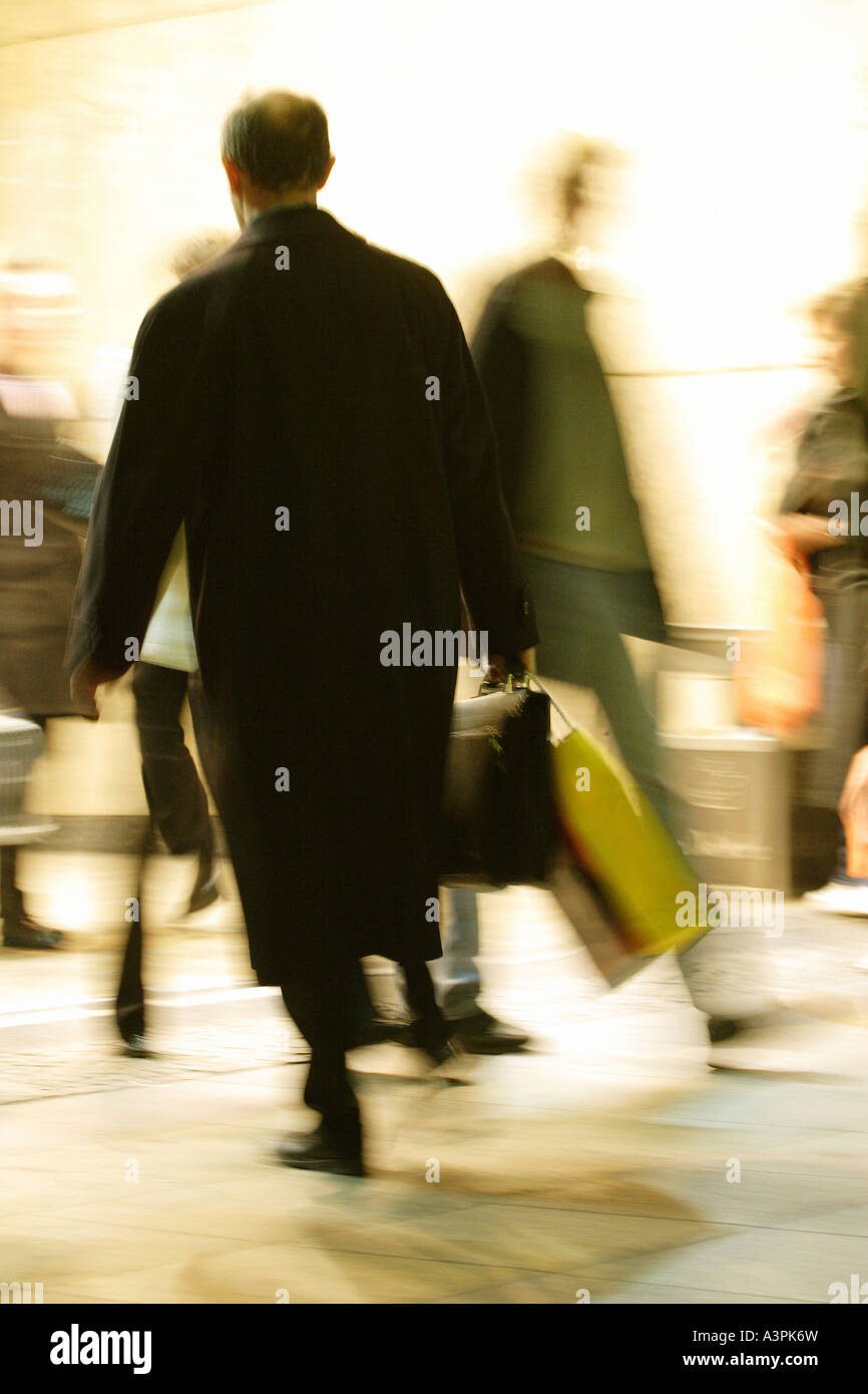 Man with suitcase and bag walking in a crowded place Stock Photo