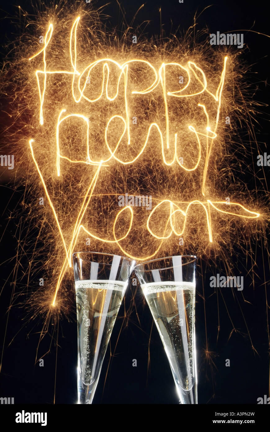 Champagne glasses and a phrase Happy New Year formed of sparklers Stock ...