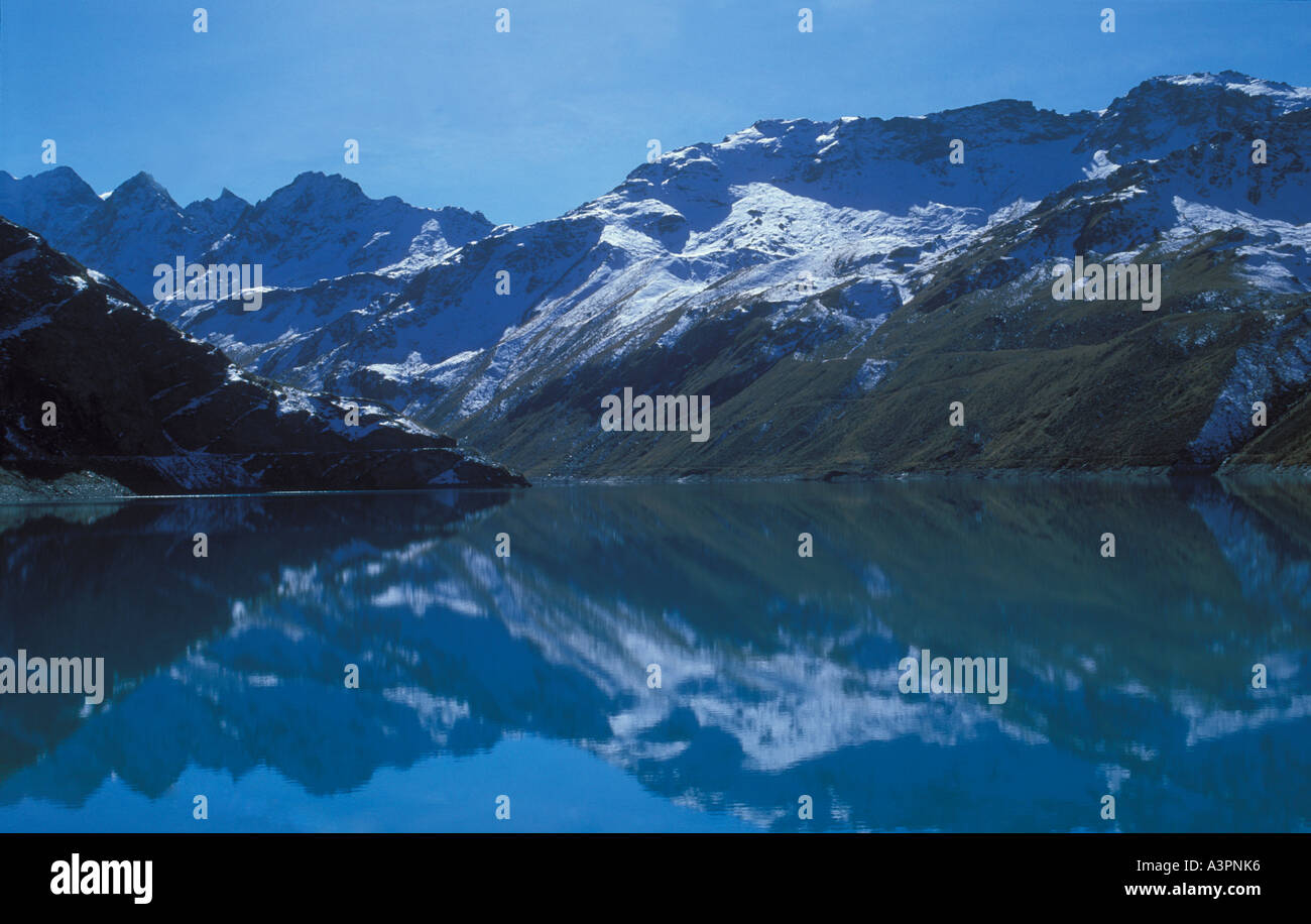 snow covered mountains reflect in lake Moiry an artificial lake for hydroelectric power production Valais alps Switzerland Stock Photo