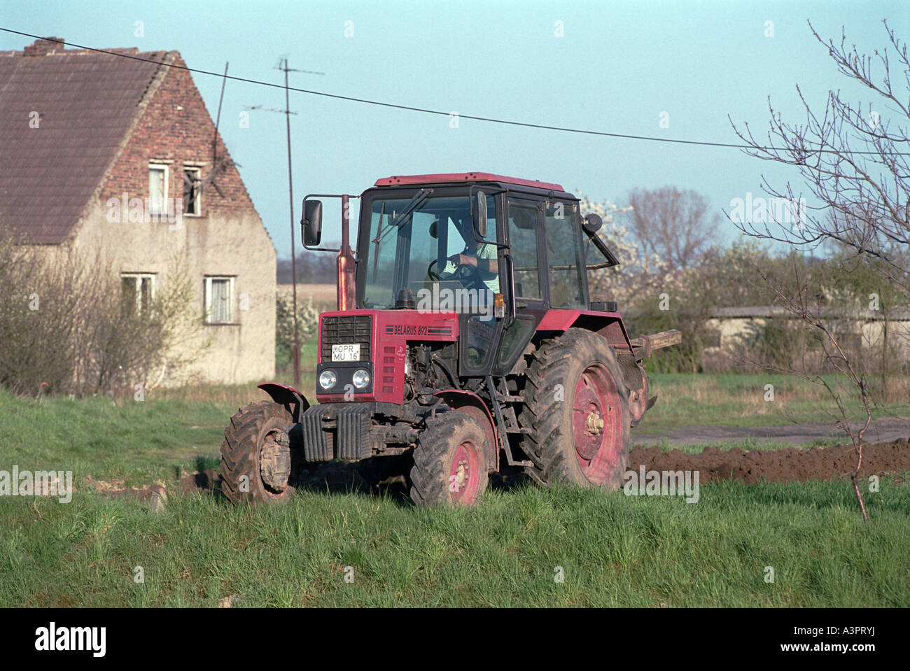 Farmer in a tractor plowing his field, Neuruppin, Germany Stock Photo