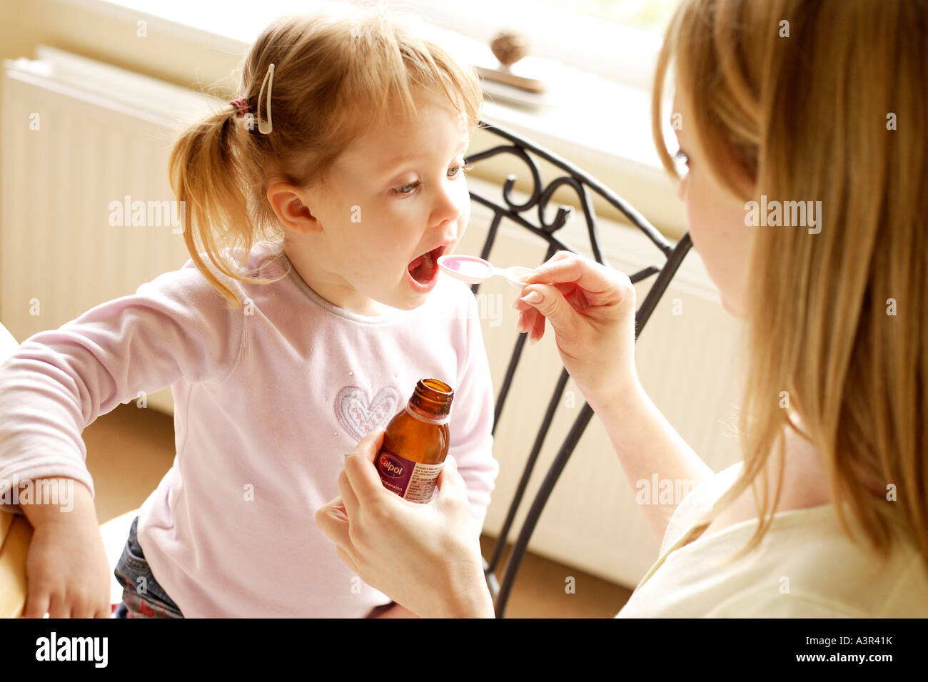 Mother giving daughter medicine Stock Photo Alamy
