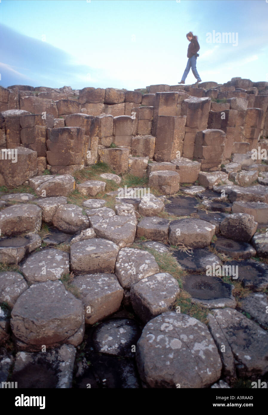 Red Haired Irish woman walking on the real Giants Causeway Northern Ireland Stock Photo