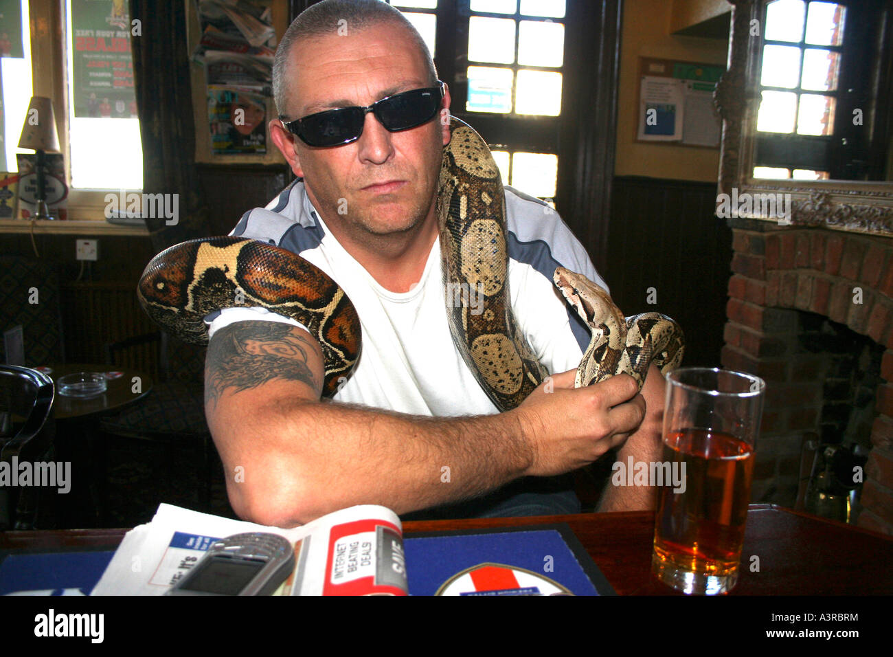 man in pub with pet snake Stock Photo