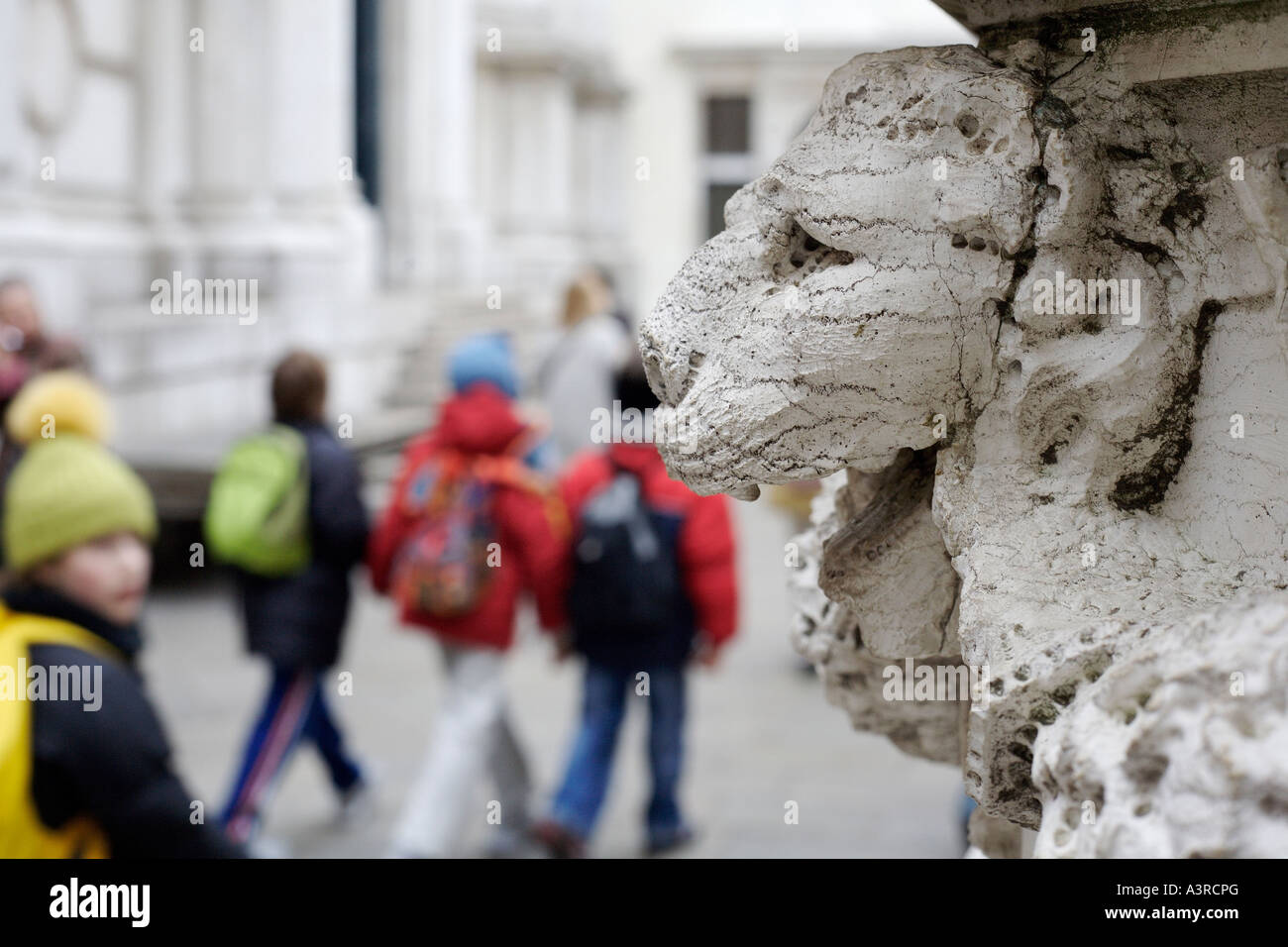 Children and carved lion head. Venice, Italy Stock Photo