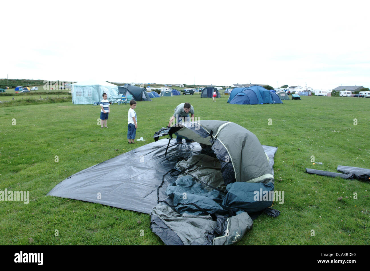 Man putting up a tent with the help of two children  Stock Photo