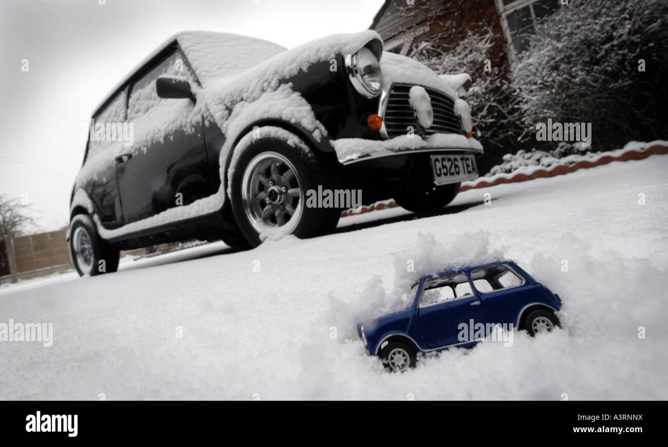 CLASSIC ROVER MINI CAR IN SNOW WITH MODEL MINI CAR COVERED IN SNOW.UK Stock Photo