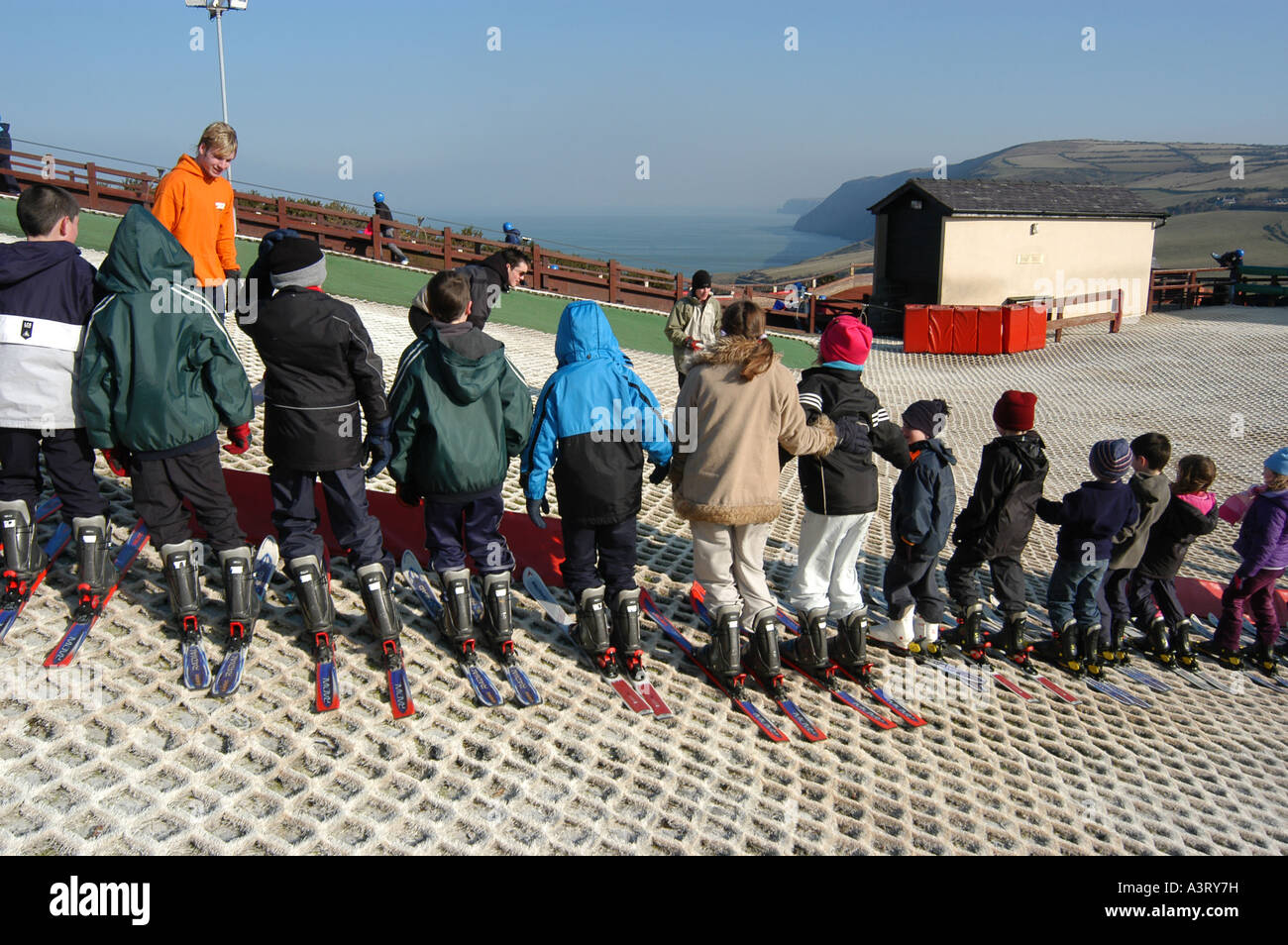 children lined up for skiing lesson on dry artificial ski slope at the Urdd Centre  Llangranog Ceredigion west wales UK Stock Photo