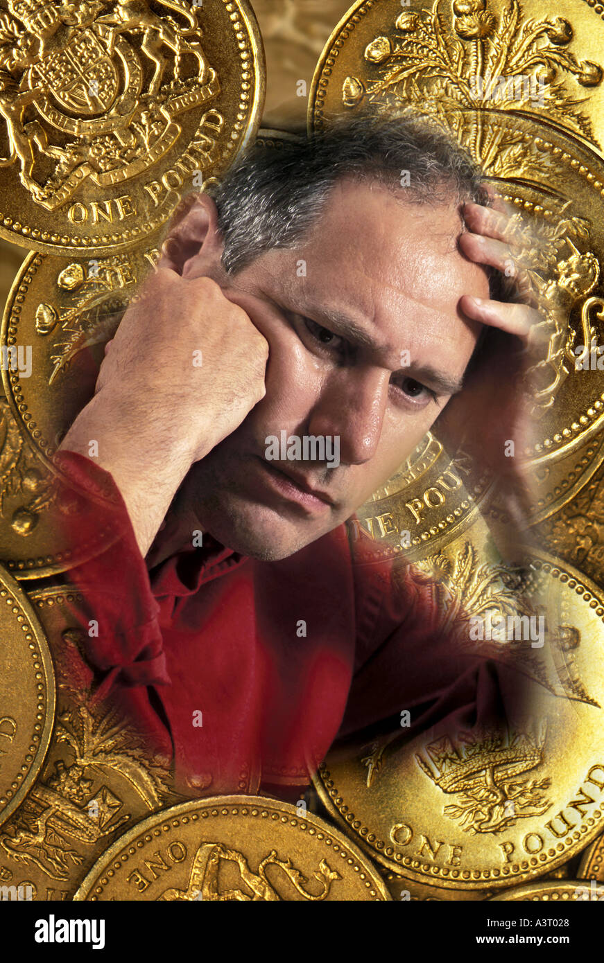 UK Pound coins with man holding head with money problems Stock Photo