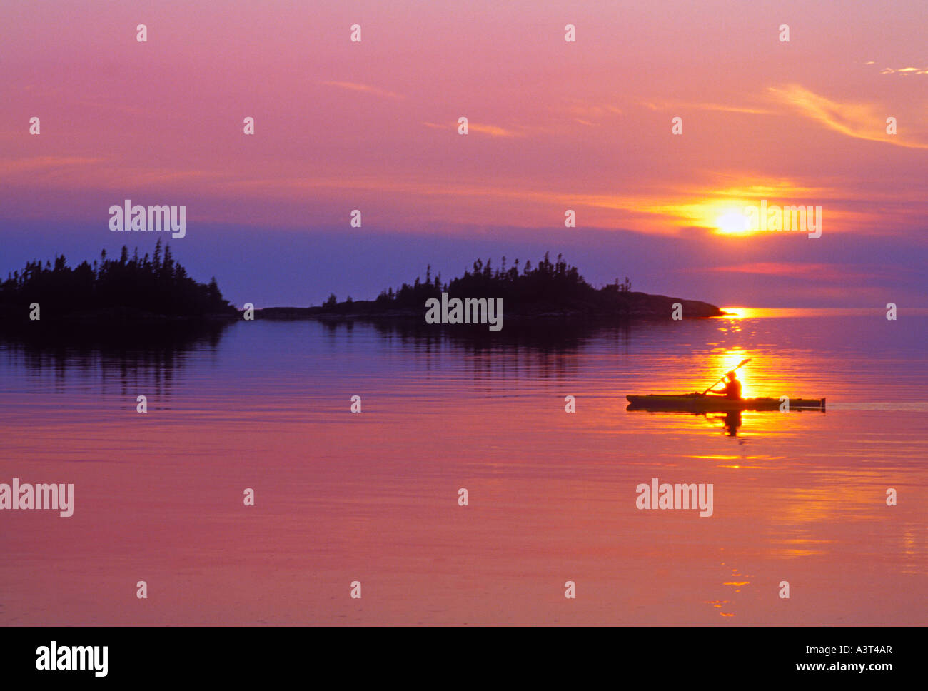 A kayaker is silhouetted at sunset on Lake Superior in Pukaskwa National Park near White River Ontario Stock Photo