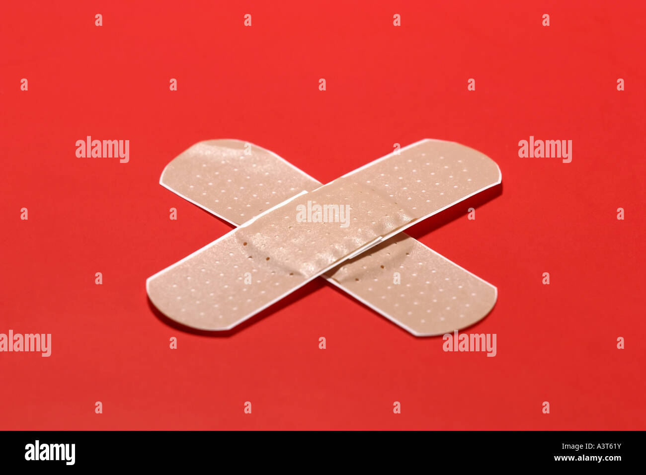 crossed bandaids against red background Stock Photo Alamy