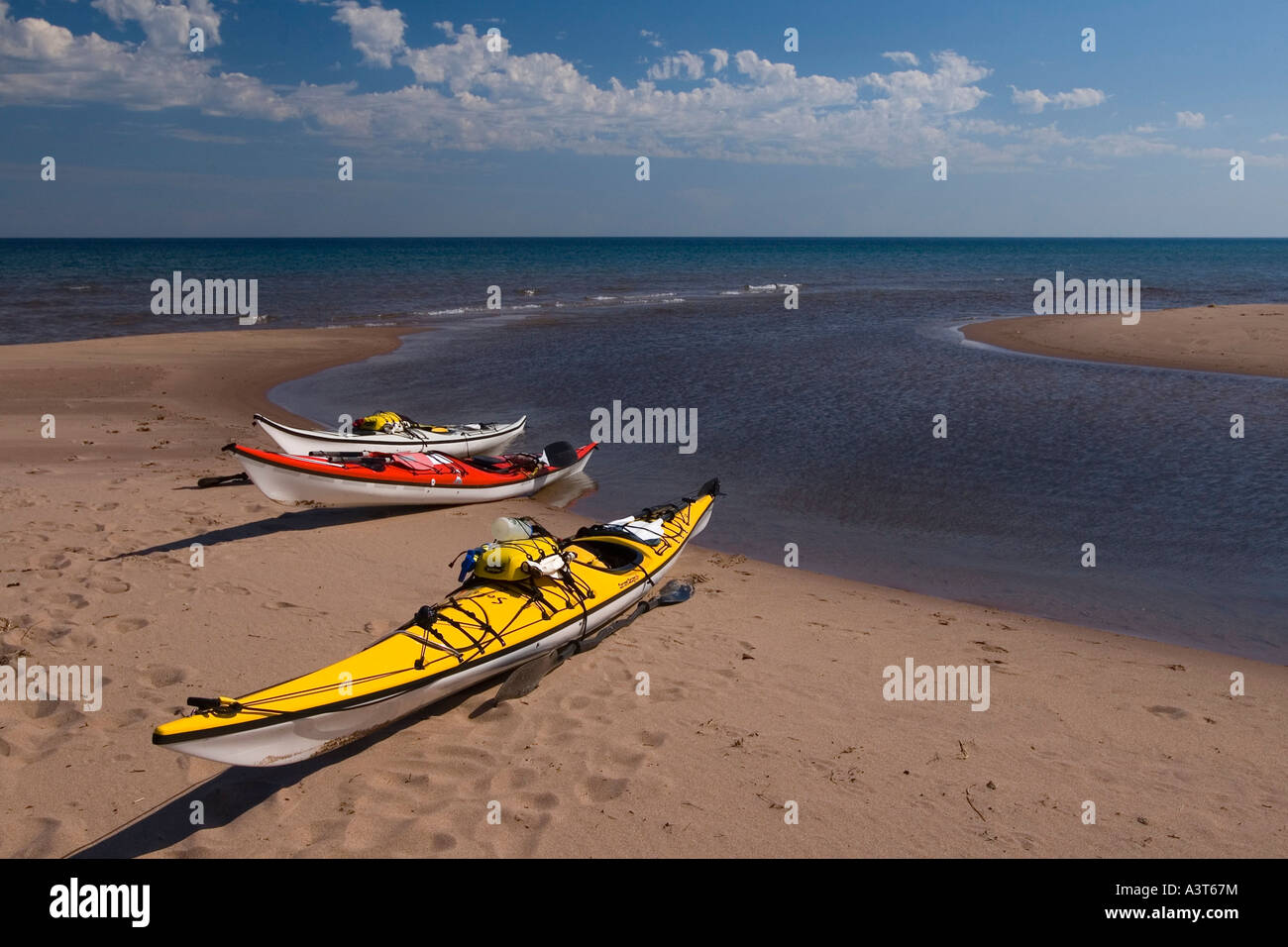 Sea kayaks on a sand beach at the mouth of the Iron River near Big Bay ...