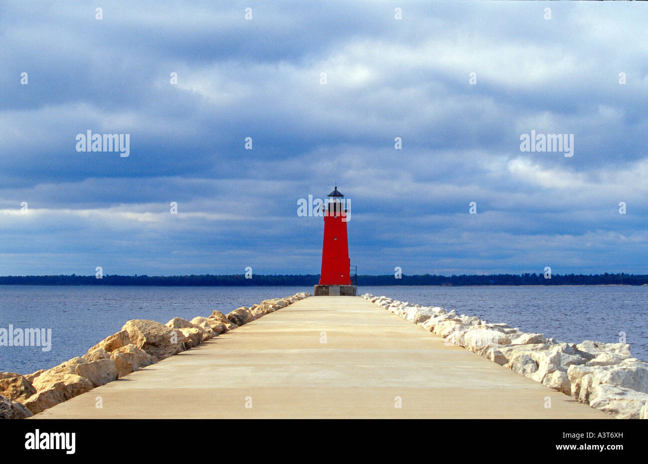 THE MANISTIQUE LIGHTHOUSE AND BREAKWATER AT THE MOUTH OF THE MANISTIQUE RIVER IN MANISTIQUE MICHIGAN Stock Photo