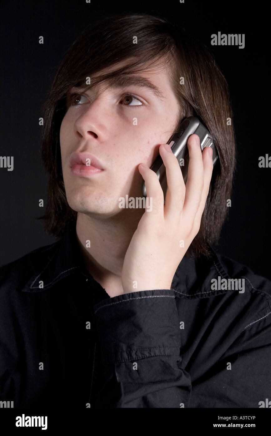 Young Man With Long Dark Hair On A Mobile Phone Stock Photo