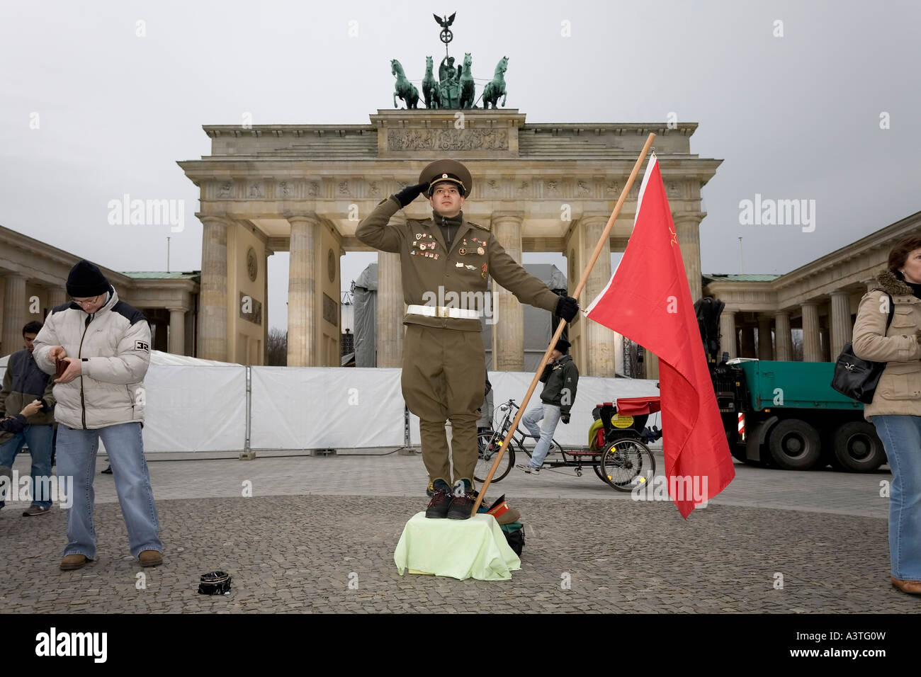 A man dressed up as a soviet army soldier poses in front of the Brandenburger Tor, Berlin Stock Photo