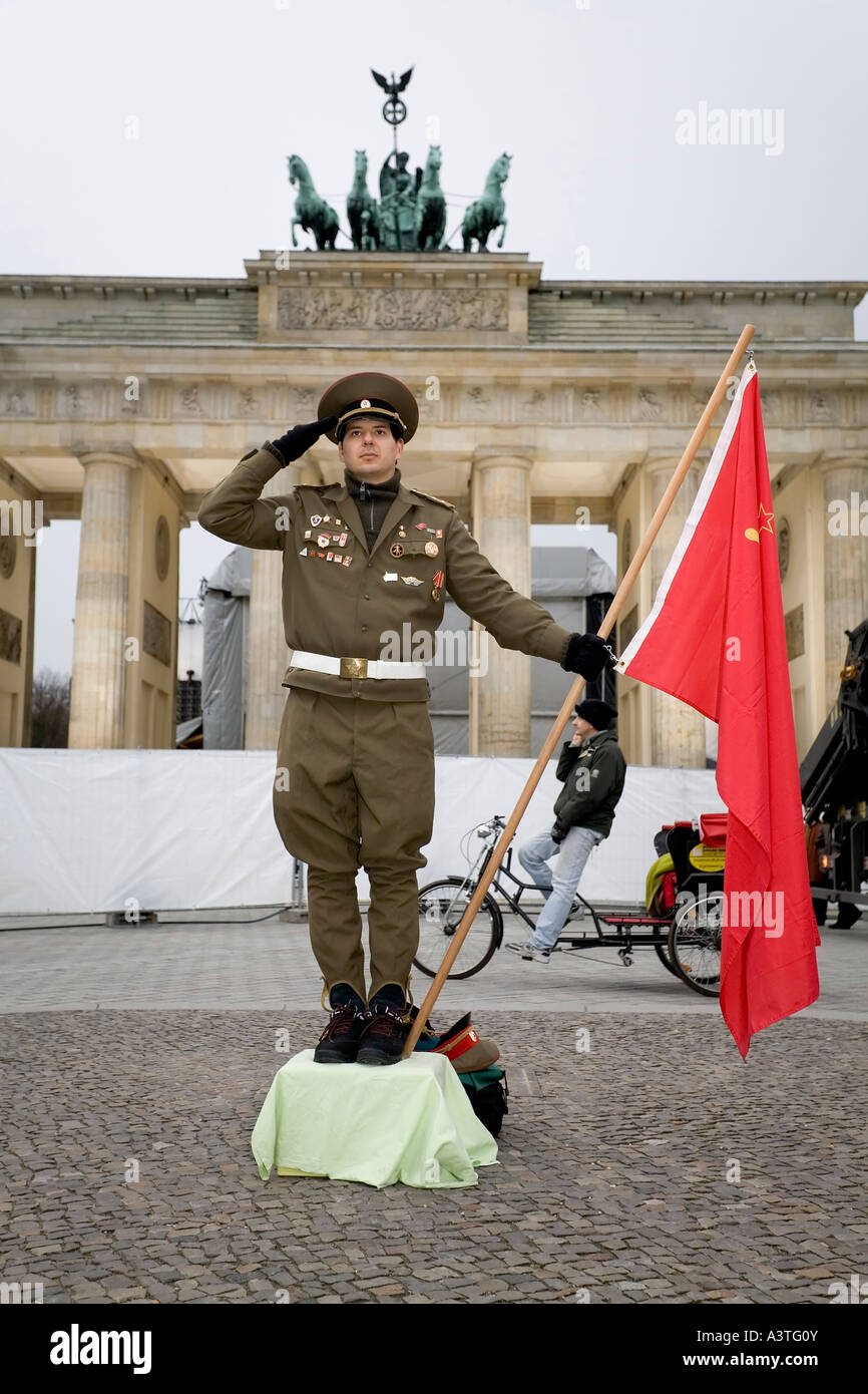 A man dressed up as a soviet army soldier poses in front of the Brandenburger Tor, Berlin Stock Photo