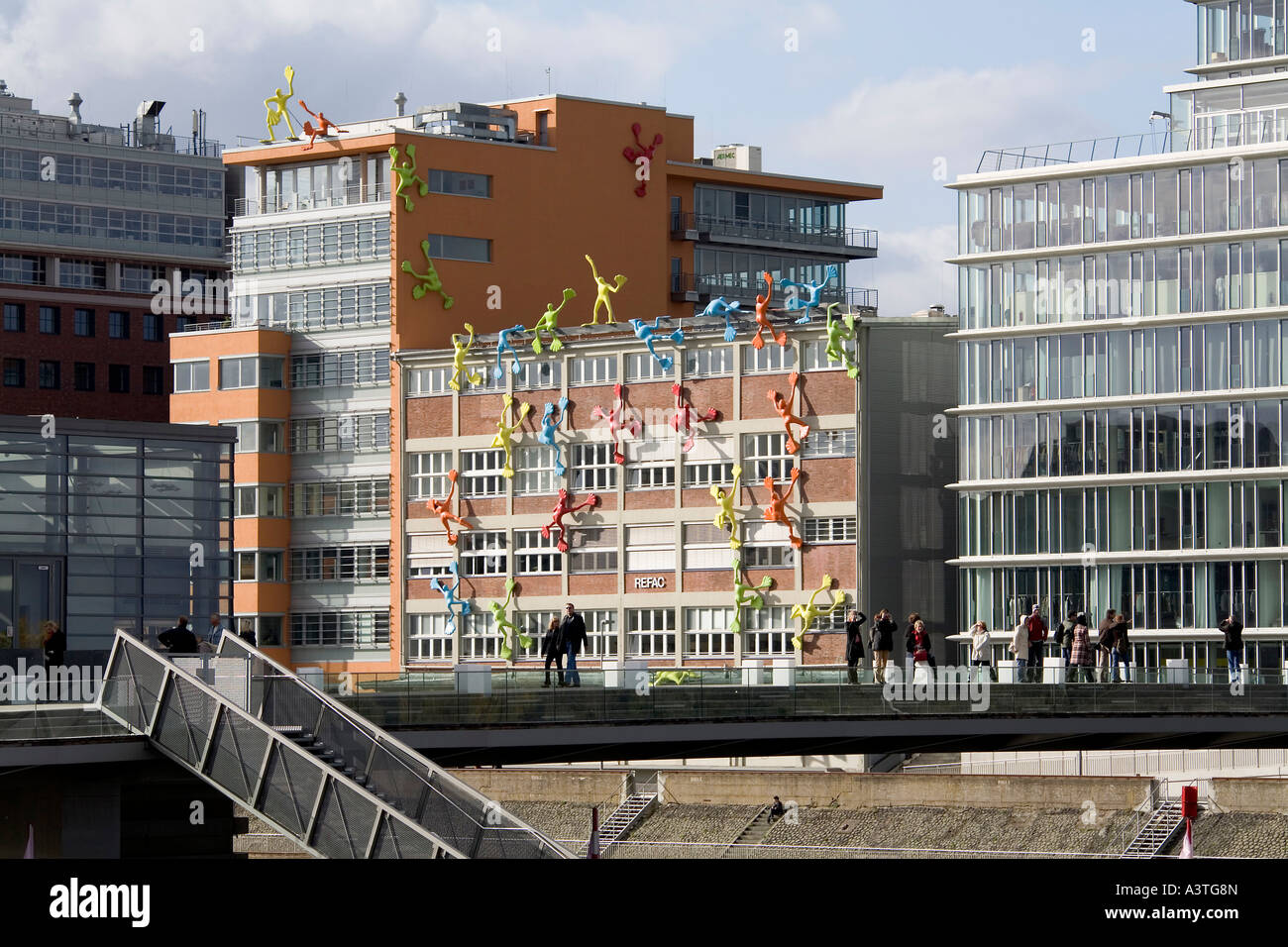 Colored figures oft the artist rosalie climb up the fassade of a storehouse at the media harbour Duesseldorf, NRW, Germany Stock Photo