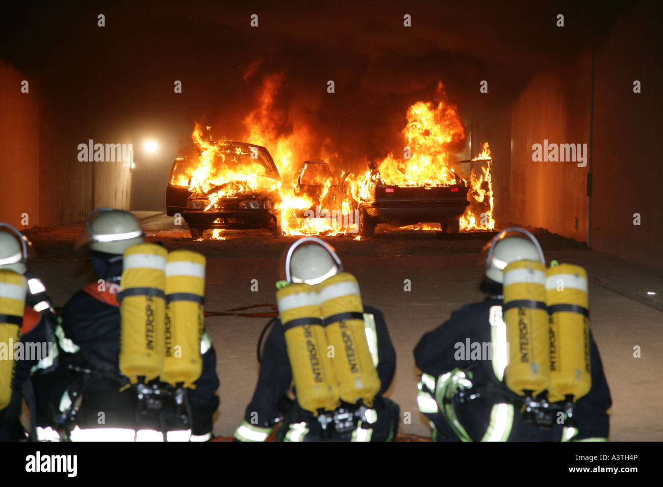 Firefighters are in a fire drill in a road tunnel near Bad Ems (Germany).Their mission is to extinguish the fire of two burning Stock Photo