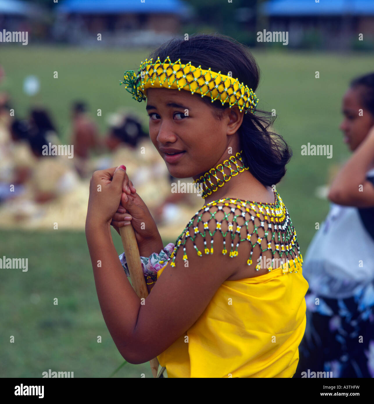 Young female dancer from the Northern Marianas Islands in yellow traditional costume with beaded yolk and head band Stock Photo
