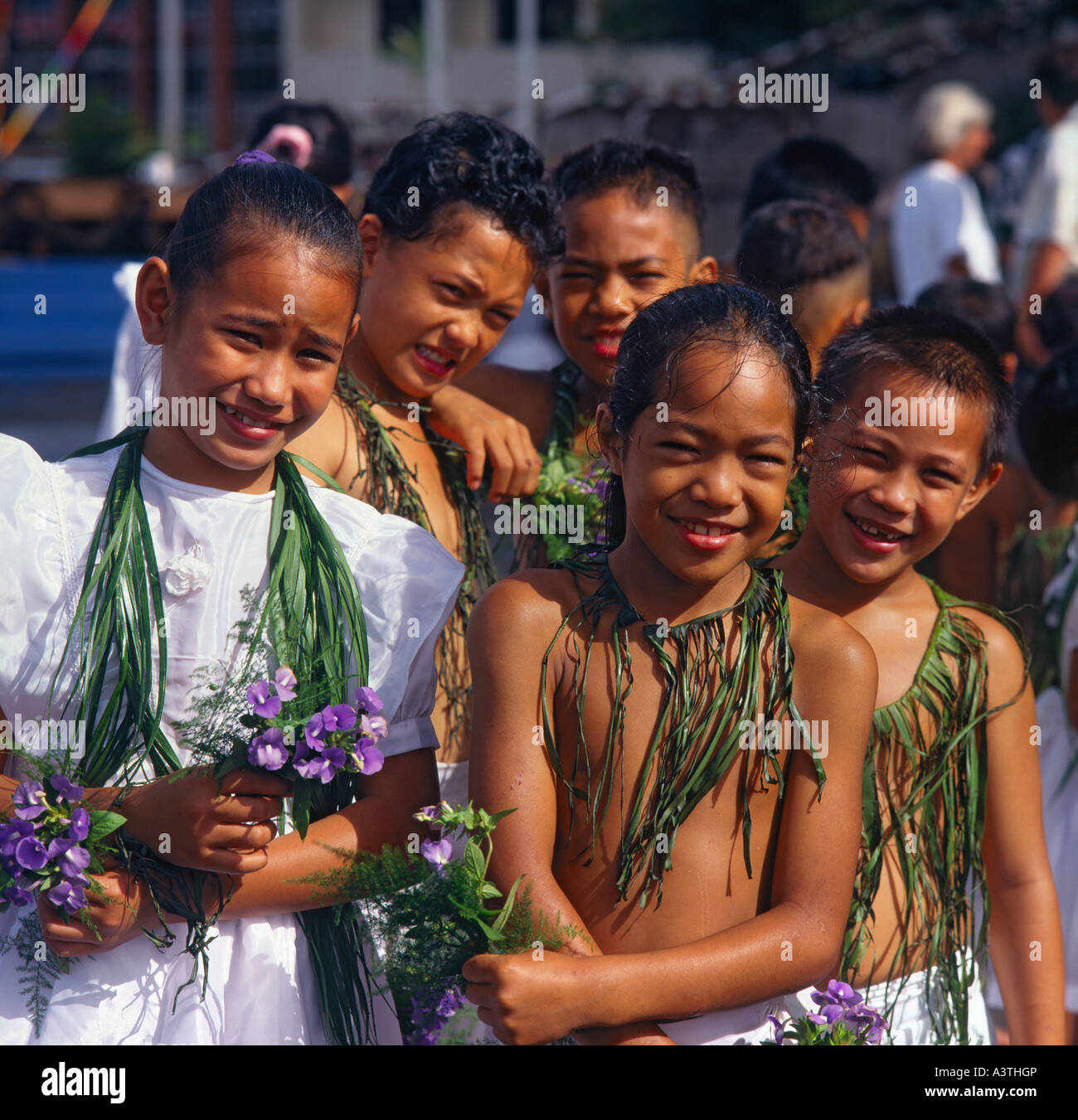 Young boy & girl dancers from the Northern Marianas Islands in traditional grass necklaces & girl with white dress and flowers Stock Photo