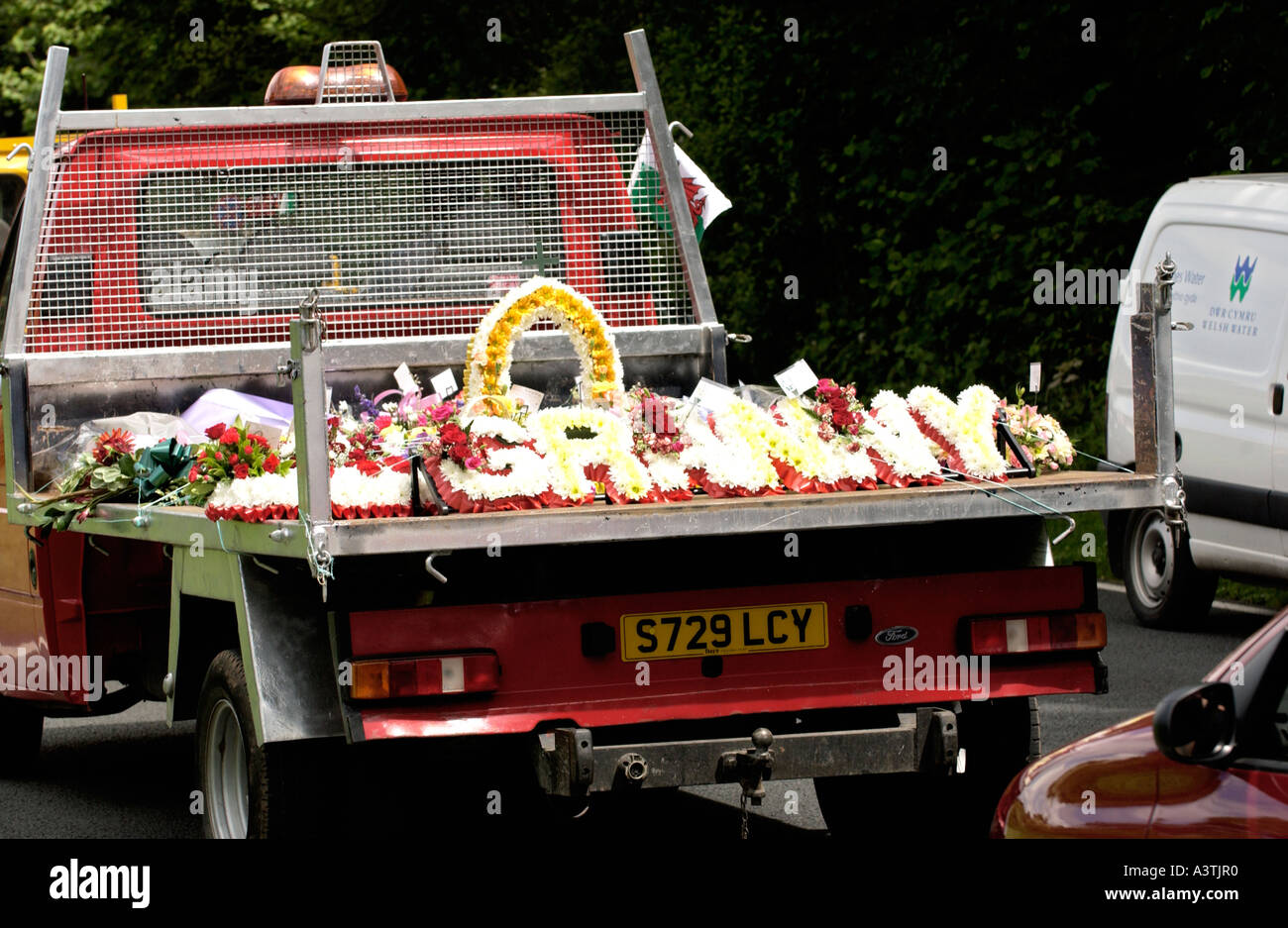 Traditional gypsy funeral cortege with flowers carried on flatbed truck