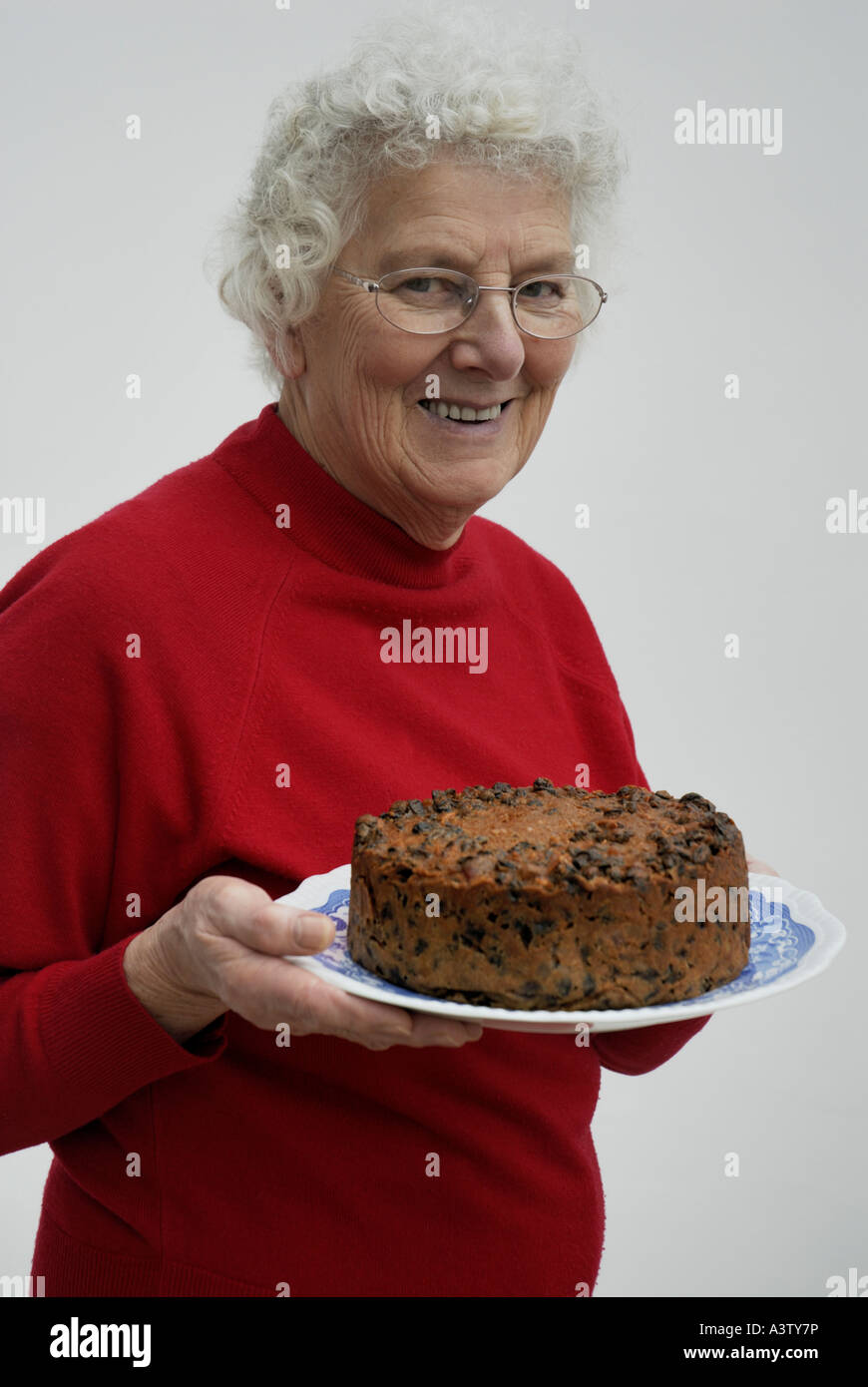 Granny holding home baked fruitcake Stock Photo Alamy