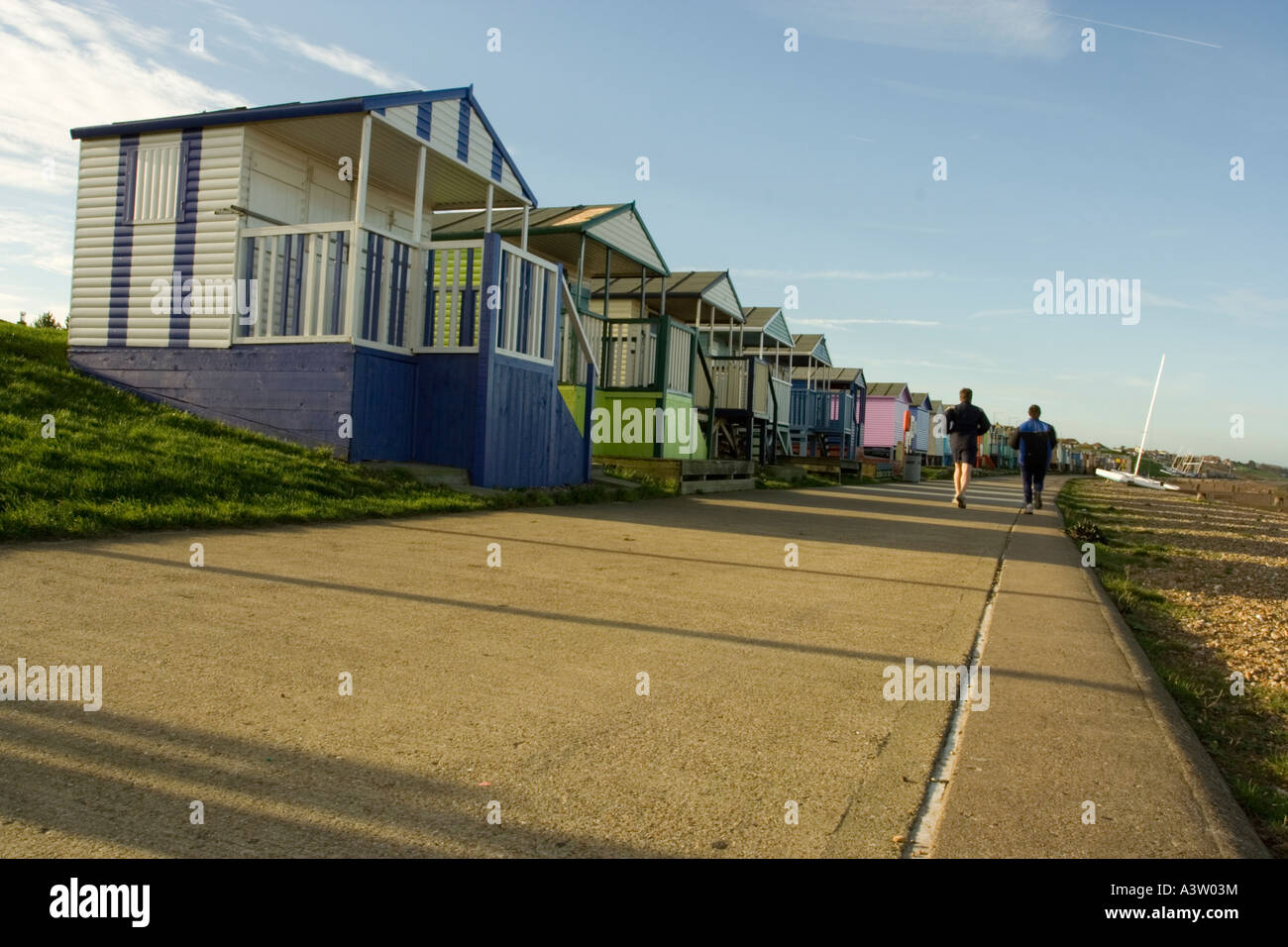Joggers in front of beach huts . Tankerton Kent Stock Photo