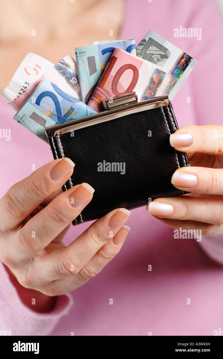 Woman holding purse stuffed with Euro currency notes Stock Photo - Alamy
