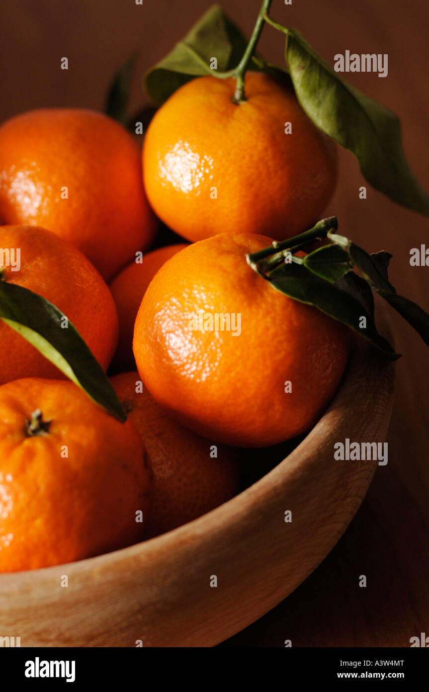 Bowl of clementines with leaves on wooden table Stock Photo Alamy