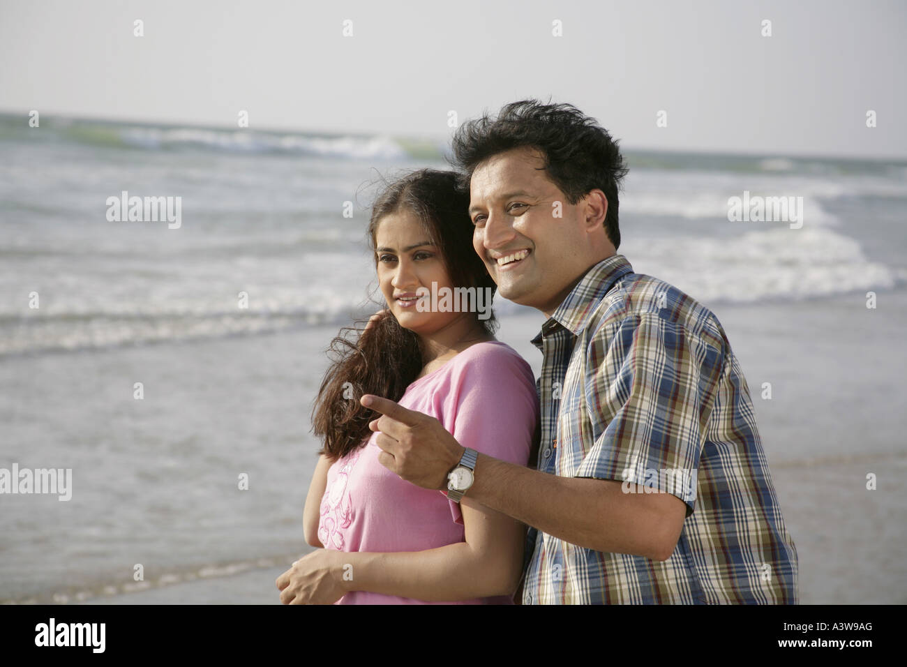 Couple playing on holiday enjoying on beach with sun sand sea Stock Photo