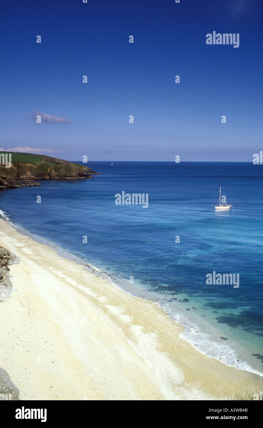 Yacht moored off Porthbeor Beach on the Roseland Peninsula in Cornwall, UK Stock Photo