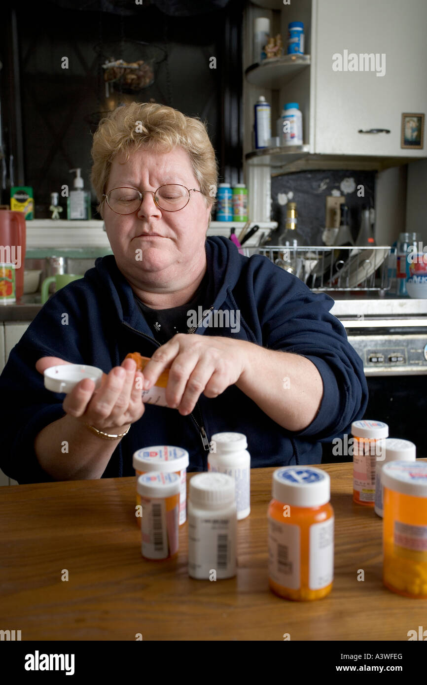 Photo of a Woman Taking Prescription Medication in Her Home, Illustrating High Costs of Medication for People Without Insurance Stock Photo