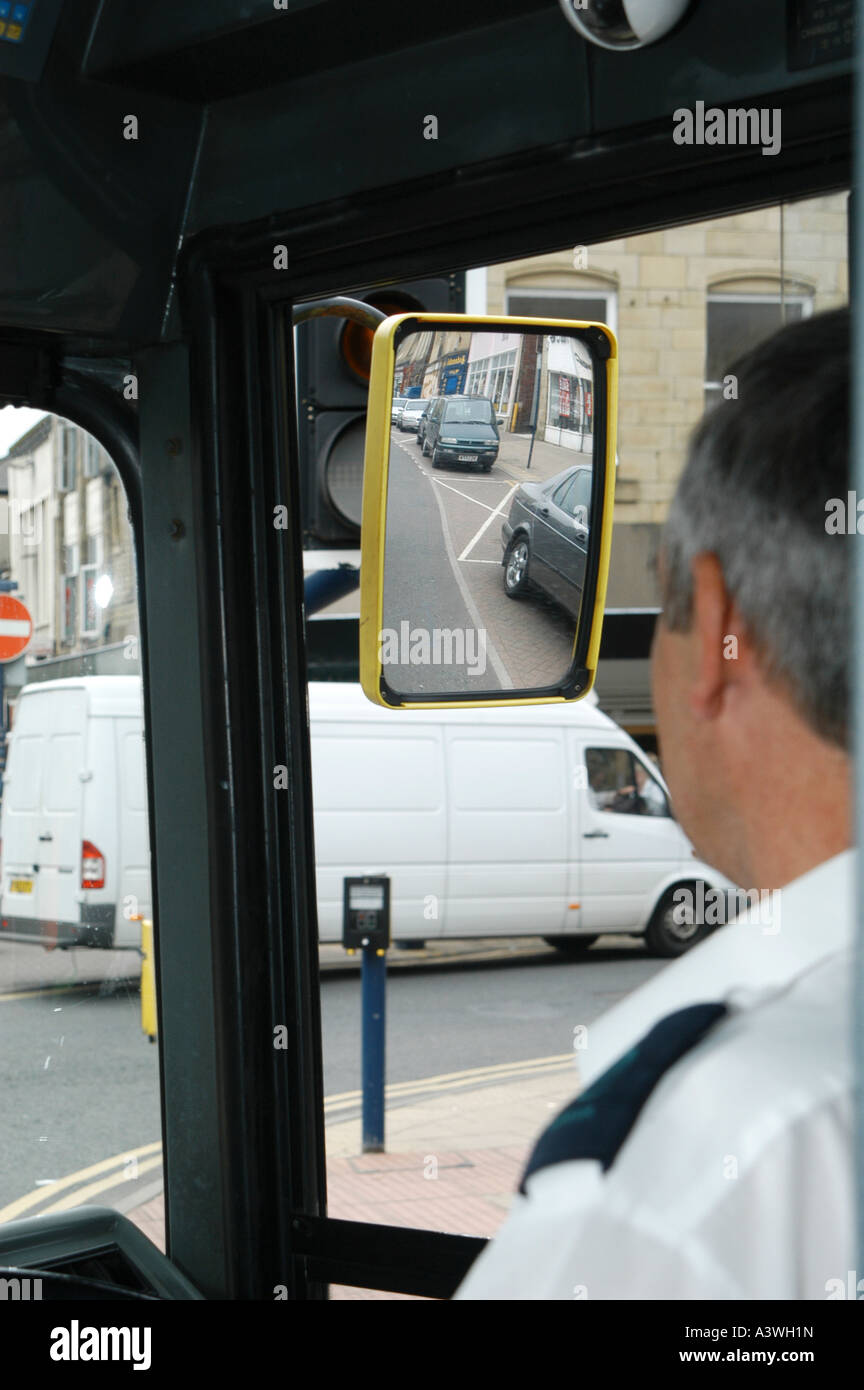 Bus driver driving a bus through a city centre street in the uk Stock Photo