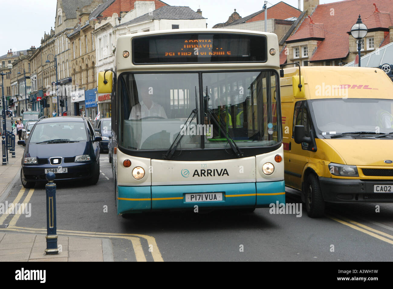 An arriva bus struggles to pass a delivery van that is causing an obstruction on a street in the uk Stock Photo