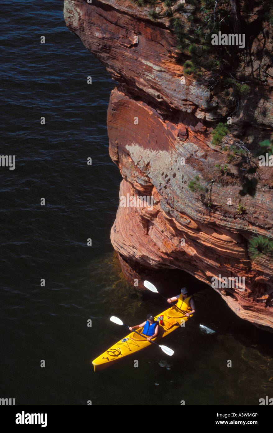 KAYAKERS IN A TANDEM KAYAK EXIT A SEA CAVE AT SQUAW POINT IN THE APOSTLE ISLANDS NATIONAL LAKESHORE NEAR BAYFIELD WISCONSIN Stock Photo