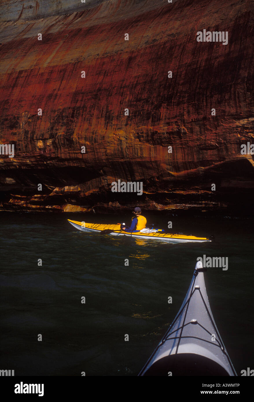 Sea kayakers explore the colored cliffs of Pictured Rocks National