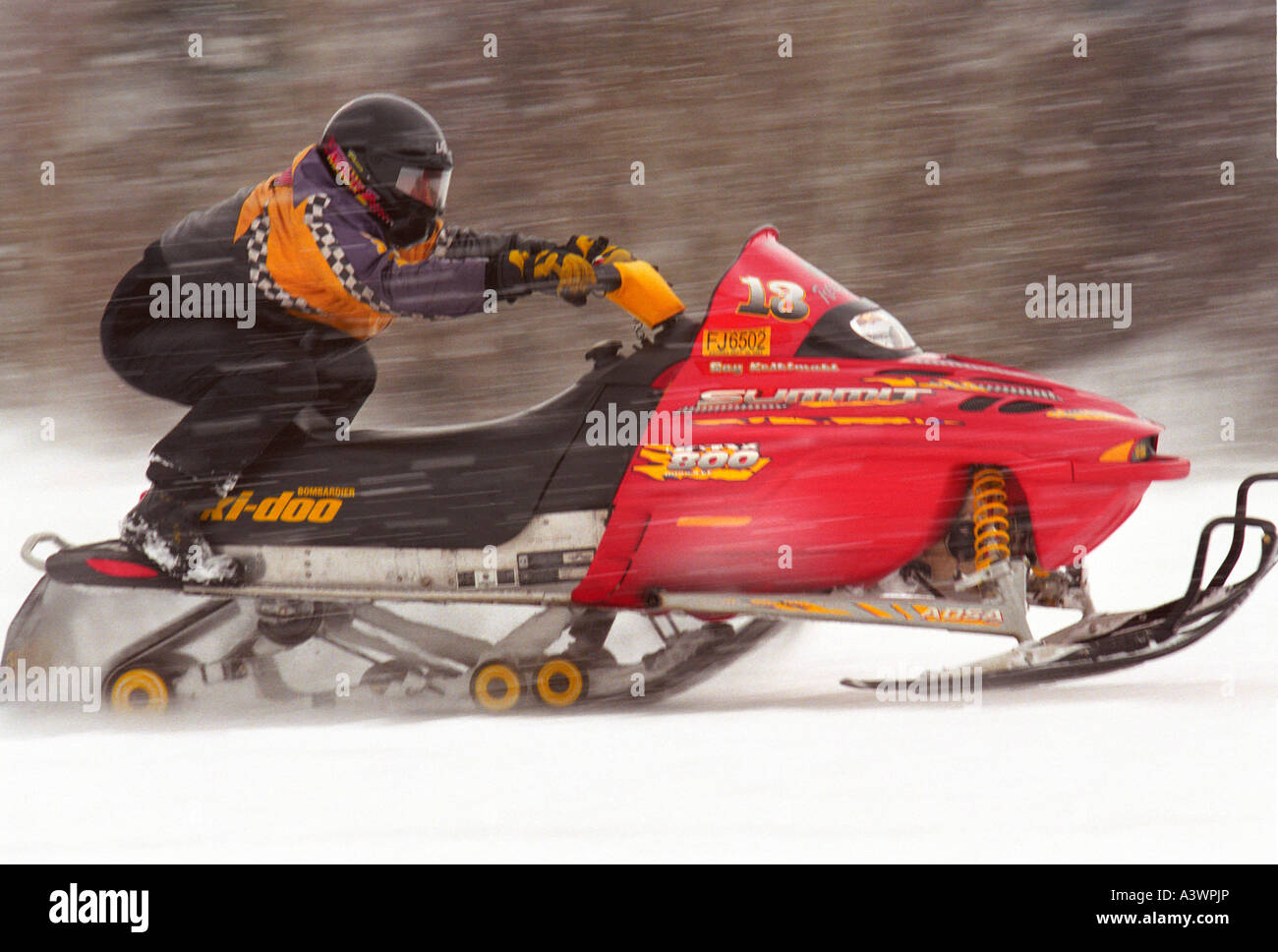 A SNOWMOBILER RACES IN A HILL CLIMB EVENT AT MARQUETTE MOUNTAIN SKI